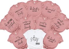 a bunch of pink shirts with names on them and one white shirt that says bride