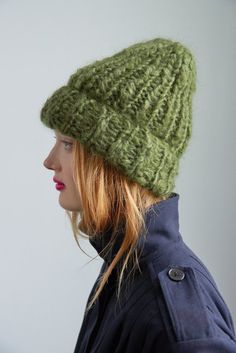 a woman wearing a green knitted hat