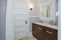 a bathroom with two sinks and a large mirror on the wall next to a door