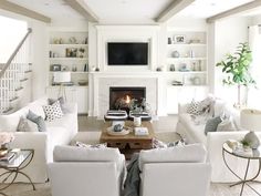 a living room filled with furniture and a fire place under a tv mounted on a wall