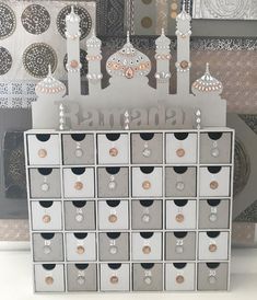 an assortment of earrings are displayed in front of a wall with many different designs on it