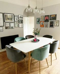 a dining room table with blue chairs and pictures on the wall above it in an instagram