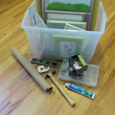 some tools are laying on the floor next to a box with tape and other items