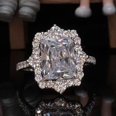 an engagement ring with a large diamond surrounded by smaller diamonds