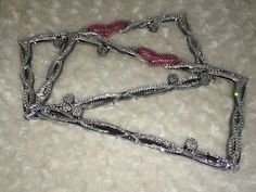 two pieces of silver and pink beaded necklaces on a white carpeted surface