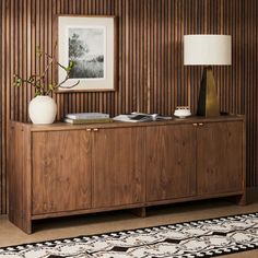 a living room with wood paneling and a rug on the floor