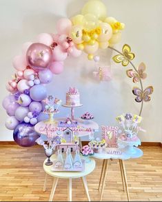 a table topped with lots of balloons and cake