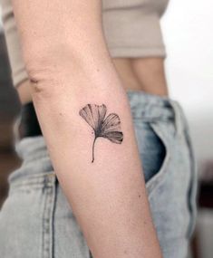 a woman's arm with a single flower tattoo on it