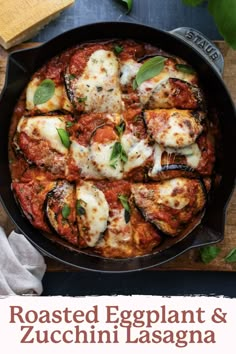 a skillet filled with pasta and sauce on top of a wooden cutting board next to basil leaves