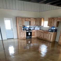 an empty kitchen with wooden cabinets and stainless steel stove top ovens in the center