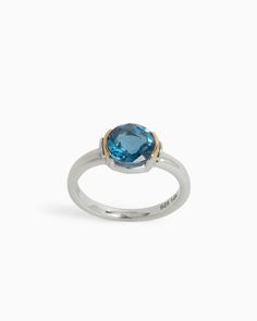 The Gemstone Ring is meticulously handcrafted in gently hammered sterling silver, adorned with a 14K gold half bezel that accentuates a stunning faceted London blue topaz stone. This unique design is elevated further by the presence of the iconic St. John petroglyph, intricately detailed on the side. Metal: Sterling silver with 14K gold accents Stone: London blue topaz Band Width: 3mm Stone Size: 8mm Style #: R217LB Faceted Blue Topaz Ring In Fine Jewelry Style, Faceted Blue Topaz Ring, Sterling Silver Yellow Gold Topaz Ring With Center Stone, Fine Jewelry Blue Topaz Rings With Bezel Setting, Yellow Gold Topaz Ring With Sterling Silver, Anniversary Blue Topaz Faceted Rings, Elegant Faceted Blue Topaz Rings, Sterling Silver Topaz Ring With Bezel Setting, Sterling Silver Yellow Gold Topaz Ring With Polished Finish