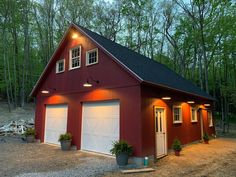 a red barn with two garages and lights on the roof is lit up at night