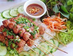 a plate filled with meat and veggies on skewers