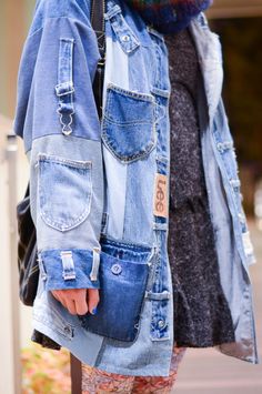 a woman wearing an oversize denim jacket and scarf with her hand in the pocket