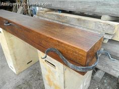 an old wooden bench is being worked on with some metal work tools in the background