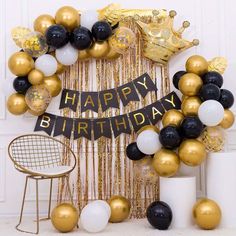 a birthday decoration with balloons and streamers in gold, black, and white colors