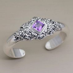 This breathtaking cuff bracelet is the creation of Nyoman Rena from Bali. Polished sterling silver is carefully wrought into vine-like openwork motifs at the center of a sleek sculpted band. A diamond-shaped four-carat amethyst in a rope-edge bezel centers the design. Edgy Jewelry, Tibetan Jewelry, Bracelet Diamond, Silver Jewels, Sterling Silver Cuff Bracelet, Sterling Silver Cuff, Gold Jewellery Design, Silver Cuff Bracelet, Diamond Bracelets