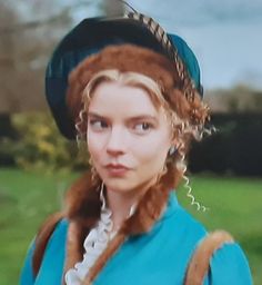 a woman in a blue dress and hat with braids on her head is looking at the camera