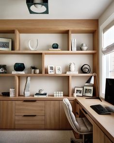 a home office with wooden shelves and white vases