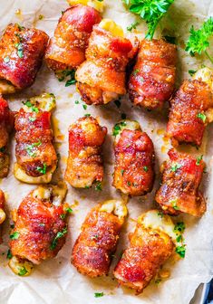 several pieces of meat wrapped in bacon and garnished with parsley on parchment paper