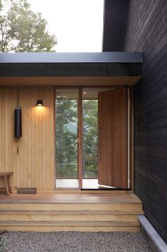 a wooden house with sliding glass doors and wood steps