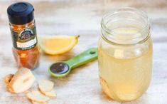 a jar filled with liquid next to sliced lemons