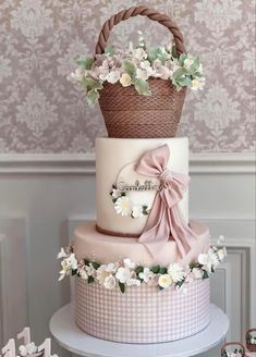 a three tiered cake decorated with flowers and a basket