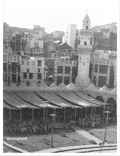 an old black and white photo of a city with lots of buildings in the background