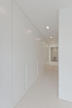 an empty room with white walls and doors leading to the other rooms in the building