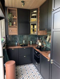 a kitchen with black cabinets and tile flooring