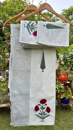 two towels hanging on a clothes line in a garden