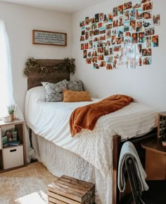 a bedroom with white walls and pictures on the wall above the bed, along with other items