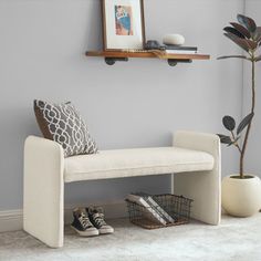 a white bench sitting on top of a carpeted floor next to a potted plant