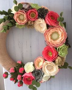 a wreath made out of paper flowers is hanging on the front door with a burlock