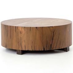 a round wooden table sitting on top of a white floor