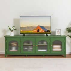 a flat screen tv sitting on top of a green cabinet