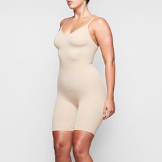 With a mid-thigh length, this essential shapewear bodysuit holds in your core, shapes and lifts your butt and chest, and smooths your upper thighs. Sculpting Shapewear Bodysuit With Built-in Bra, Compressive Seamless Shapewear, Full Coverage Compression Bodysuit With Lined Body, Compressive Shapewear Bodysuit With Built-in Bra, Compressive Shapewear Bodysuit With Medium Bust Support, Full Coverage Shapewear With Built-in Bra For Loungewear, Compression Shapewear With Seamless Construction, Compressive Solid Shapewear With Lined Body, Seamless Shapewear Bodysuit