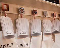 chef's hats are hanging on the wall in front of other kitchen utensils