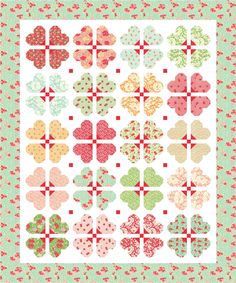 a quilt pattern with hearts and flowers on the front, in pastel green background