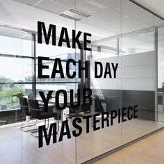 the words make each day your masterpiece appear to be written on glass in an office