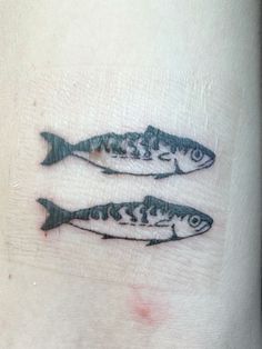 two fish tattoos on the left side of someone's right arm, one is black and white