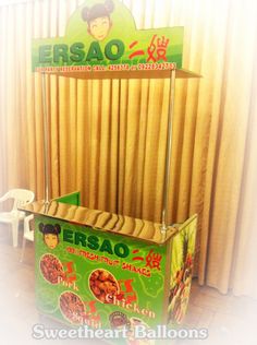 a display case for some kind of food in front of a curtained window with the word ersao written on it