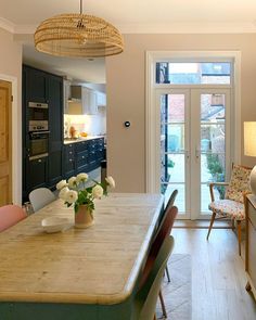 an open kitchen and dining room area with wood flooring, white walls and doors