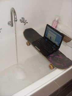 a laptop computer sitting on top of a bath tub