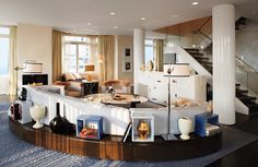 a living room filled with furniture and a fire place next to a stair case in front of a window