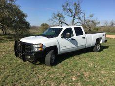 a white truck is parked in the grass