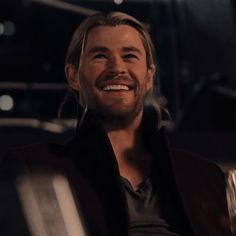 a man smiling while sitting in a chair