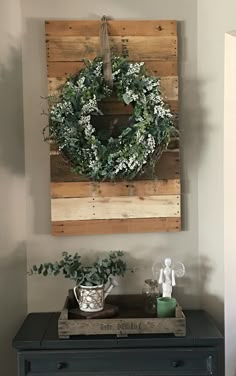 a wreath is hanging on the wall above a dresser