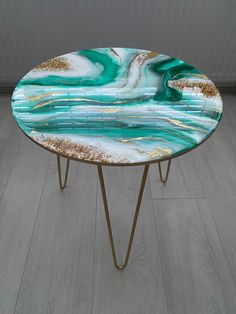 a table that has some kind of blue and gold design on it, sitting on top of a wooden floor