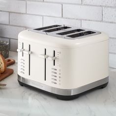 a white toaster sitting on top of a counter next to a knife and bread